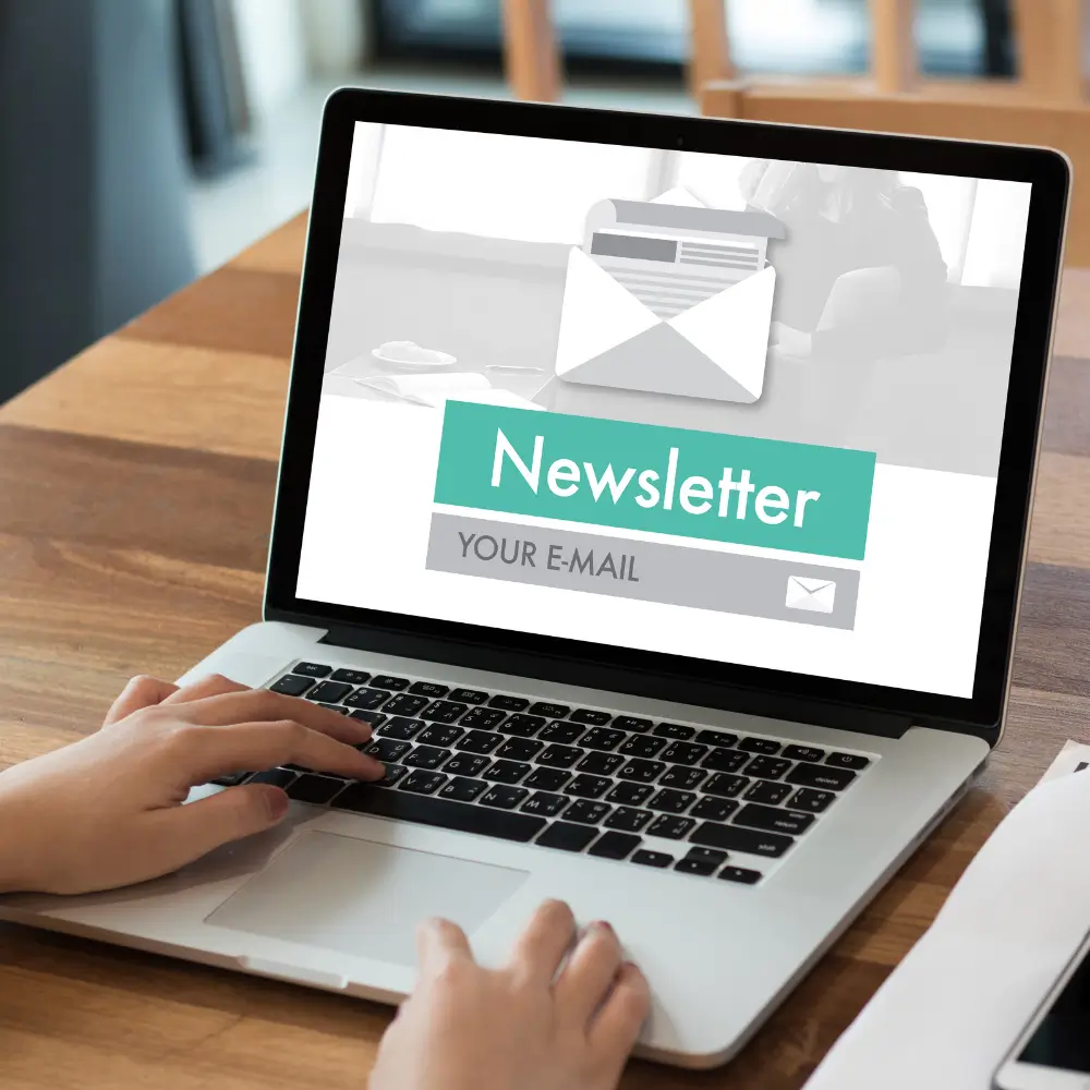Hands typing on laptop that has a newsletter signup showing on the screen