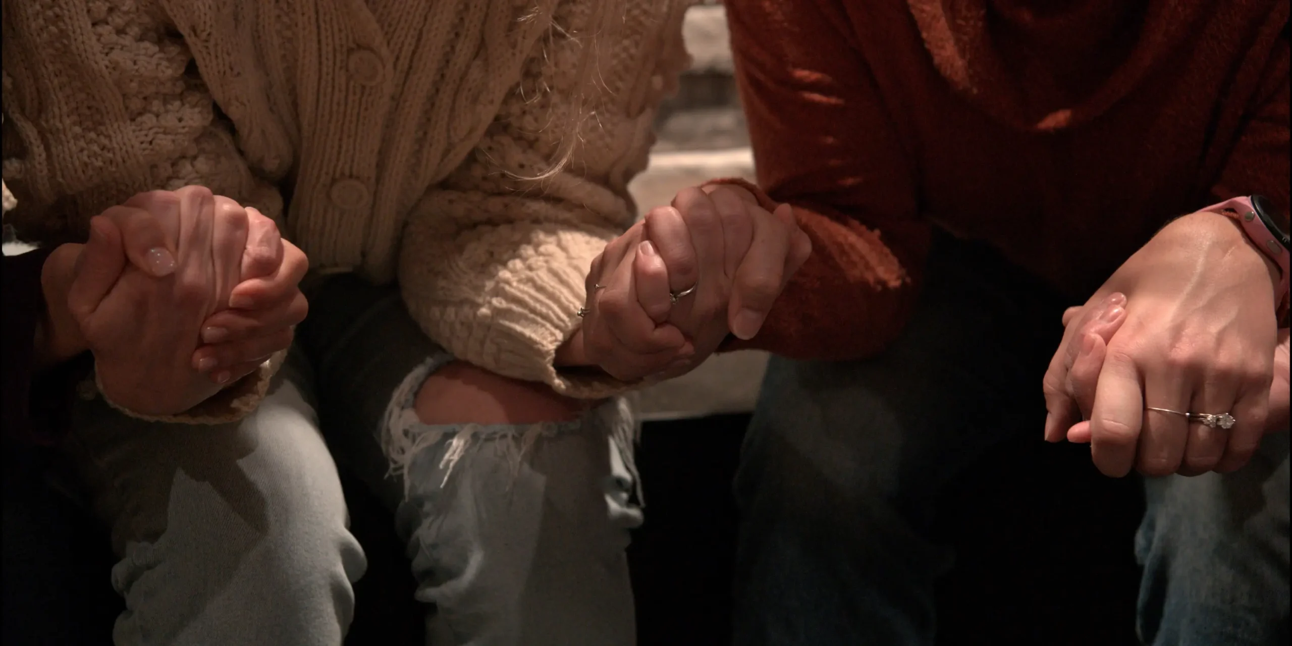 Hands of women praying together and holding hands
